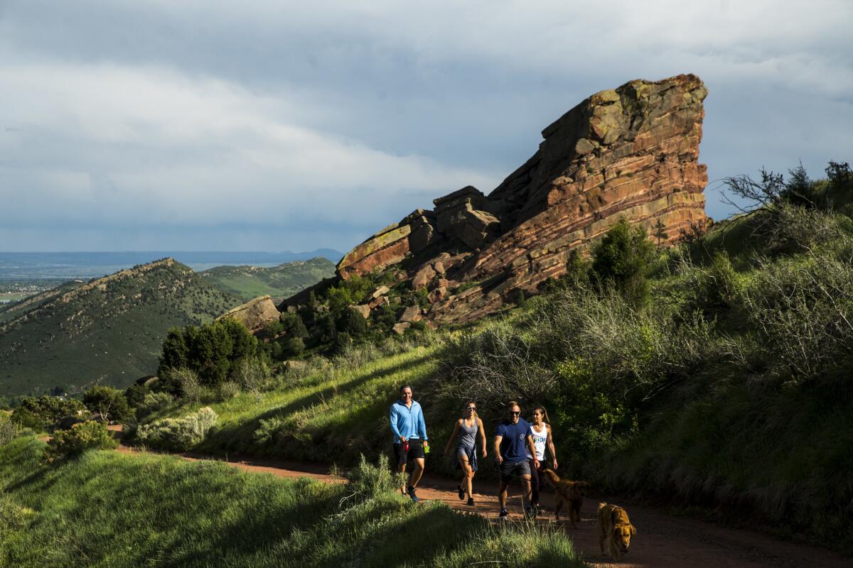 People walk the Geologic Overlook Trail, with Creation Rock in the background. (Kent Nishimura / Los Angeles Times)