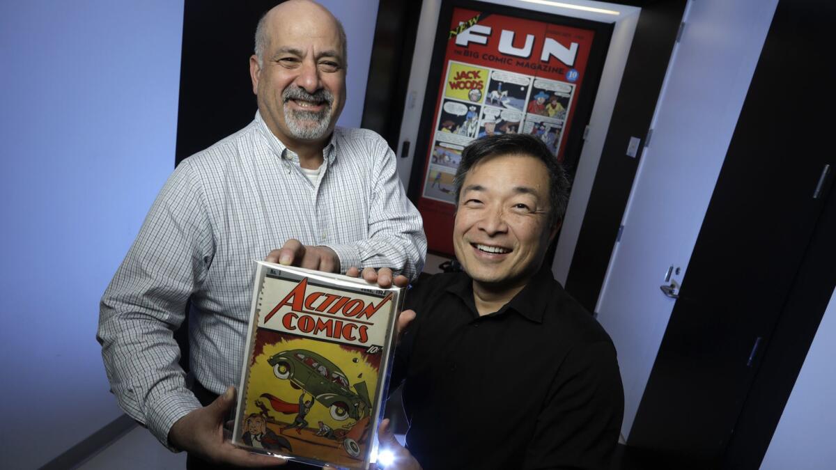 DC Comics co-publishers Dan DiDio, holding the first issue of Action Comics, and Jim Lee in 2018