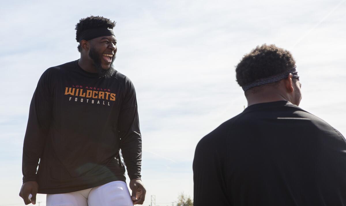 Wildcats linebacker Tre' Williams jokes around with his teammates before practice at Veterans Memorial Stadium at Long Beach City College.