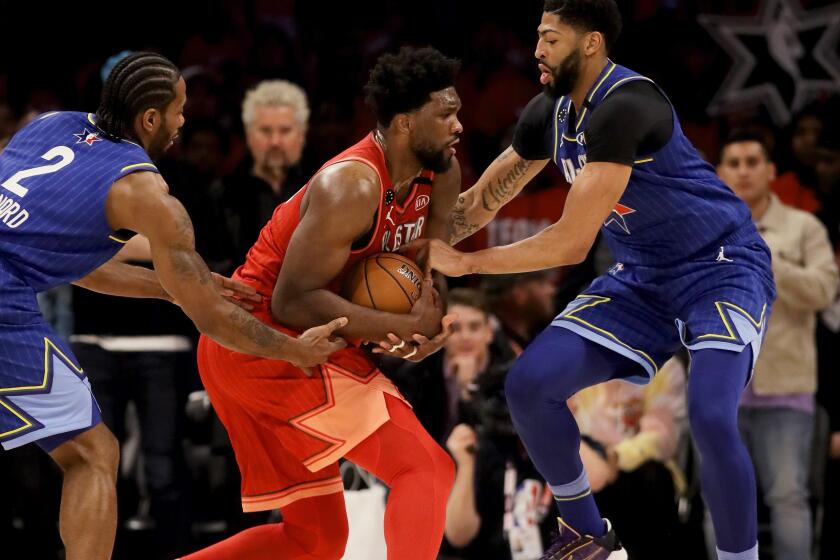 Clippers forward Kawhi Leonard, left, and Lakers forward Anthony Davis, right, trap 76ers center Joel Embiid during the NBA All-Star game on Feb. 16, 2020, in Chicago.