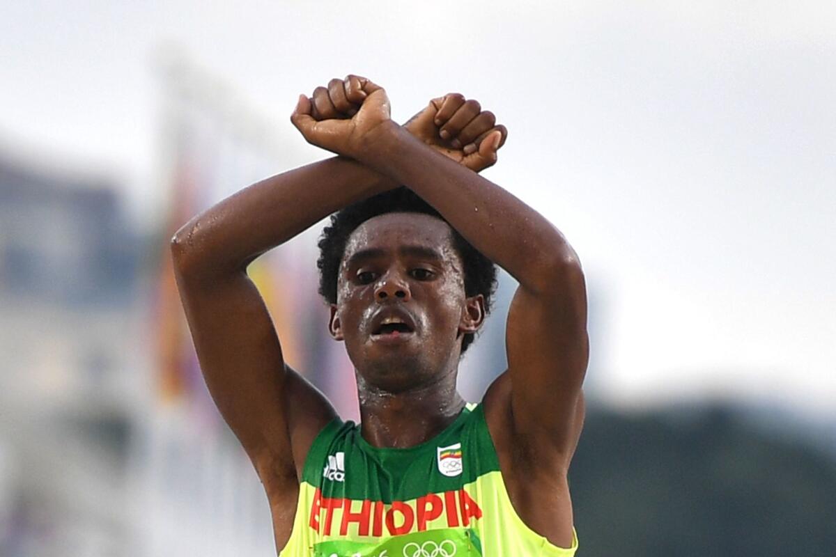Ethiopia's Feyisa Lilesa crossed his arms above his head at the finish line