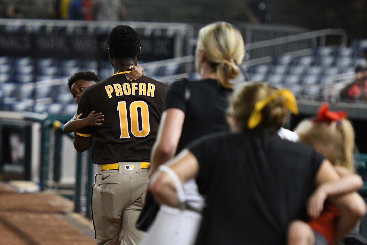 Jurickson Profar runs off the field carrying his son after shots are heard at Nationals Park during Saturday night’s game.