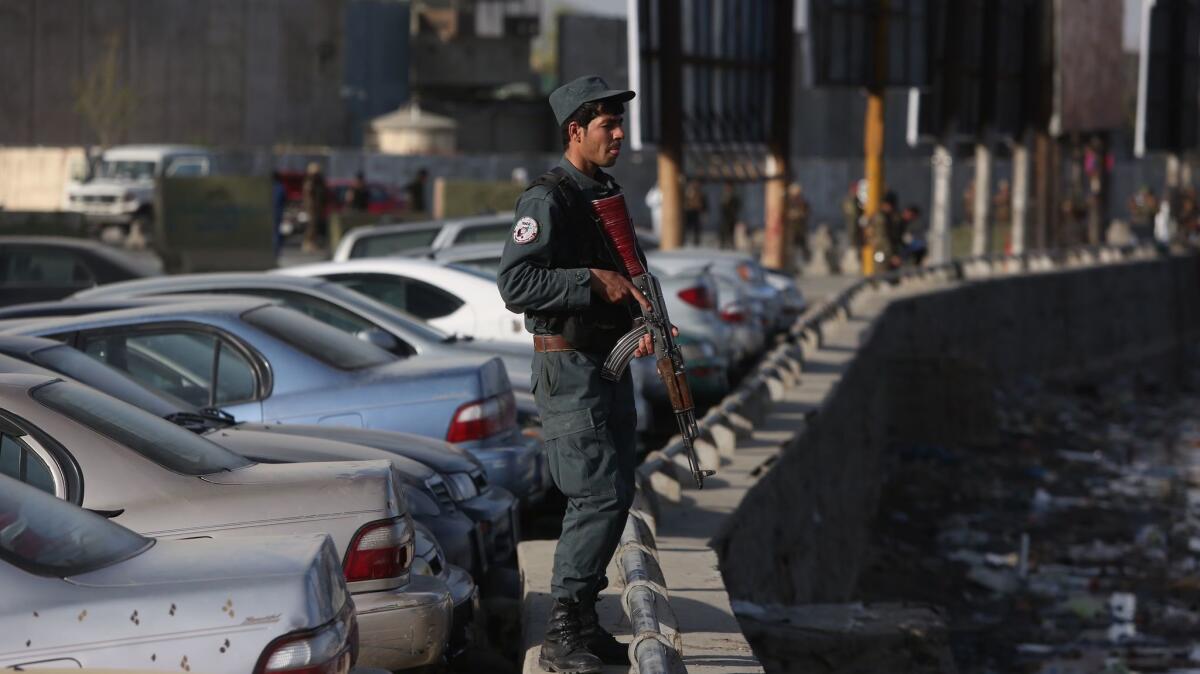 An armed security officer stands by after a suicide bomber struck near government offices in Kabul, Afghanistan, on April 12, 2017.