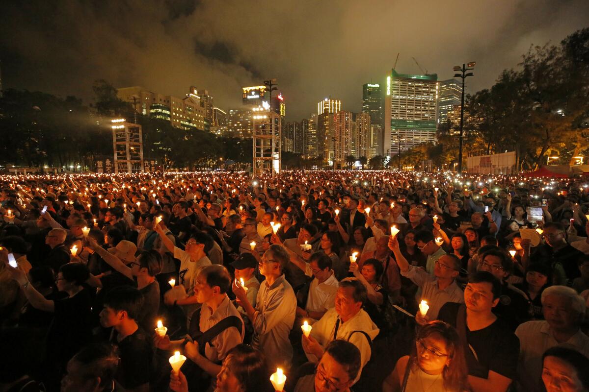 People holding aloft candles at an evening vigil in Hong Kong