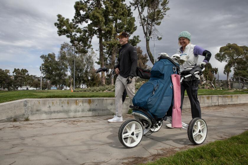 San Diego , California - March 14: Garrett Fall, 19, left, and Susan Fall walk to the next hole at Mission Bay Golf Course and Practice Center on Thursday, March 14, 2024 in San Diego , California. Amendments to the Mission Bay Park Master Plan are being proposed to revitalize the De Anza Cove. "I appreciate nature but humans need recreation and there's not a lot of places like this," said Susan Fall about the proposed changes. (Ana Ramirez / The San Diego Union-Tribune)