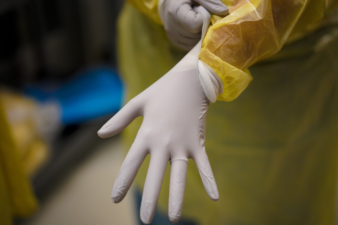 Nurses put on new gloves and gowns and wear a PAPR before entering a room with a patient who has COVID-19.
