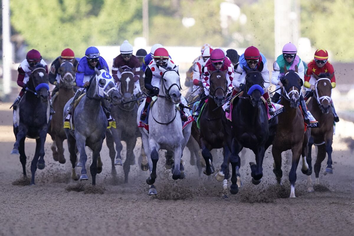 John Velazquez on Medina Spirit, third from right, leads the pack into turn one during the Kentucky Derby. 