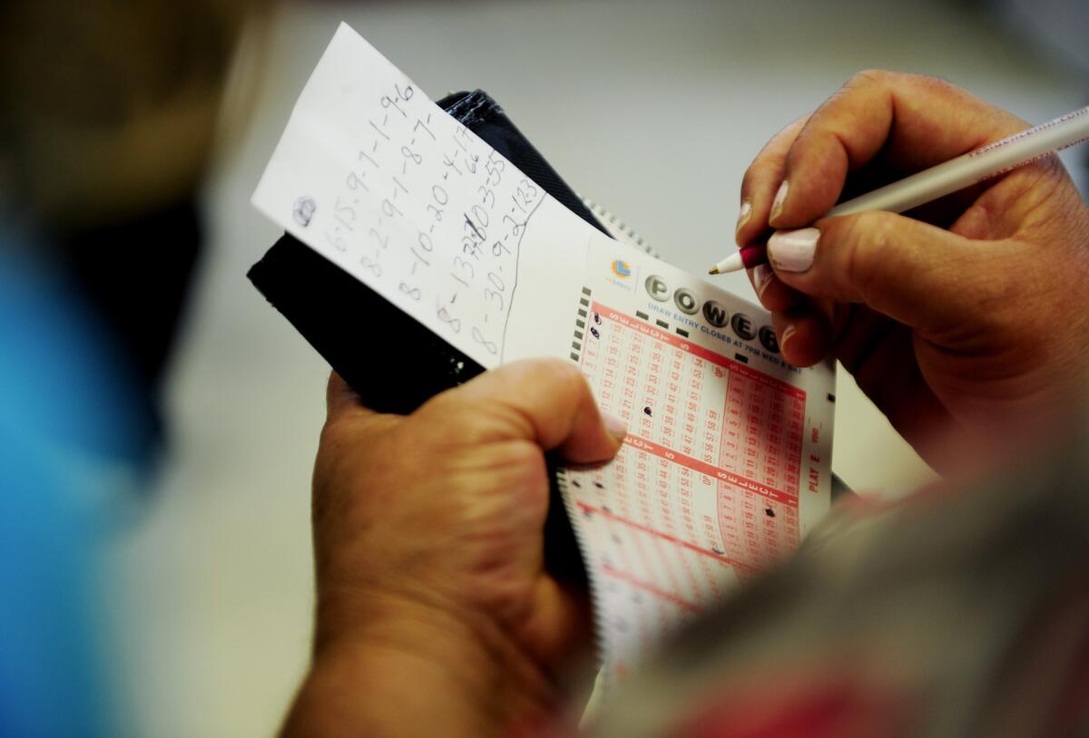 A lottery player fills out Powerball tickets at Bluebird Liquor in Hawthorne before August's $425-million drawing.