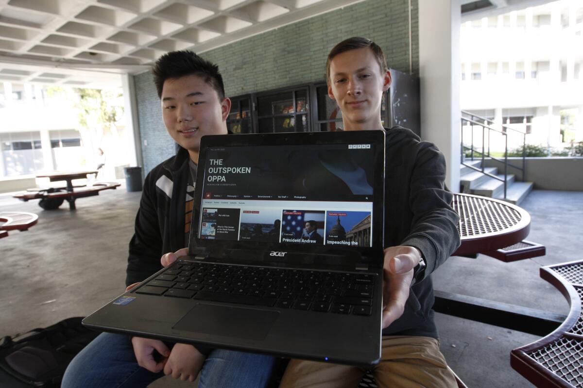 La Cañada High School juniors Ethan Kim, 16, left, and contributor Mason Pirkey, 16, display the homepage of their site the Outspoken Oppa, which aims to create a marketplace of ideas among students of varying beliefs.