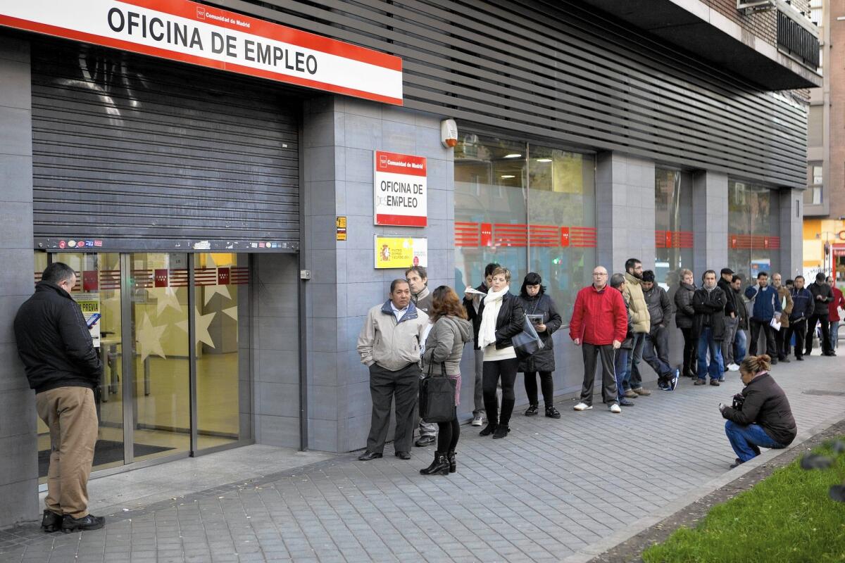 People wait at a government employment office in Madrid in December.