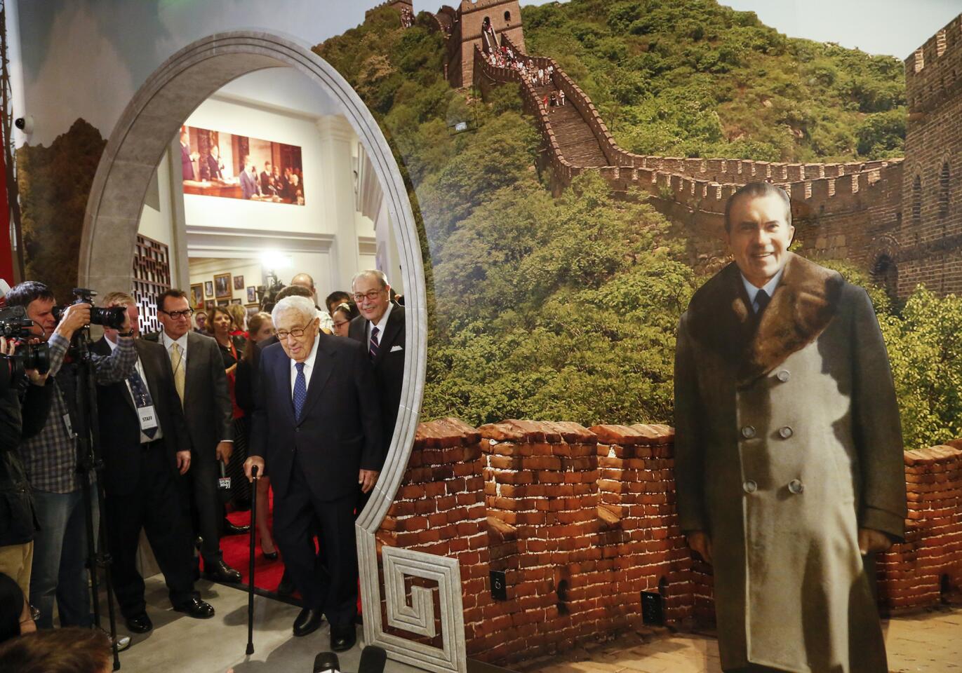 Former Secretary of State Henry Kissinger enters an exhibit in the Richard Nixon Presidential Library and Museum in Yorba Linda where guests can pose with a life-size backdrop of Nixon in front of the Great Wall of China.