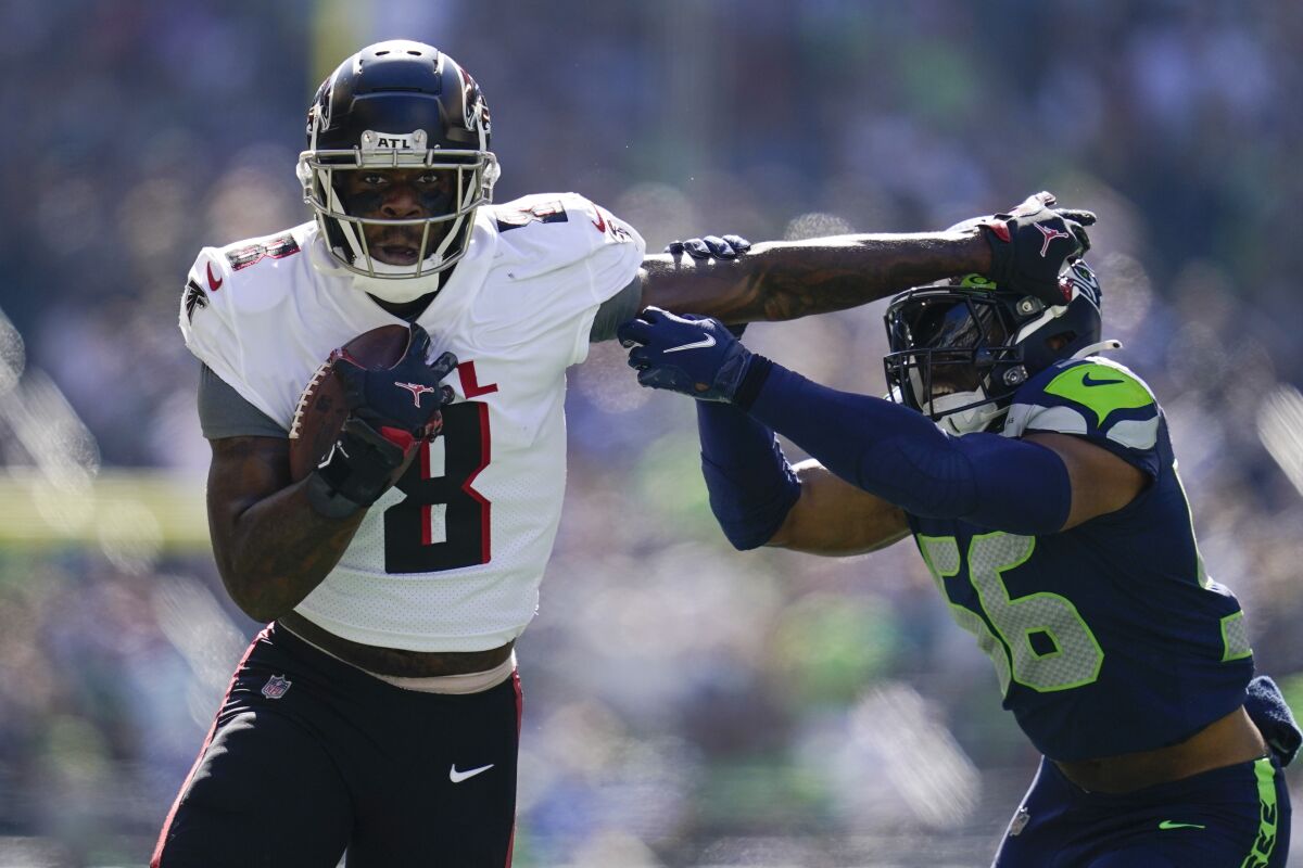 El tight end estelar de los Falcons de Atlanta, Kyle Pitts (8), logra evadir al linebacker Jordyn Brooks, de los Seahawks de Seattle, en partido del domingo 25 de septiembre de 2022, en Seattle. (AP Foto/Ashley Landis)