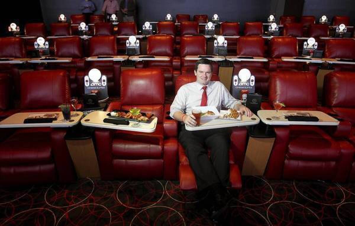 AMC spokesman Ryan Noonan sits in an AMC theater in Marina del Rey that allows patrons to order food and drink from their seats. AMC has remodeled another theater in West Hills with similar seating, but no dining services.