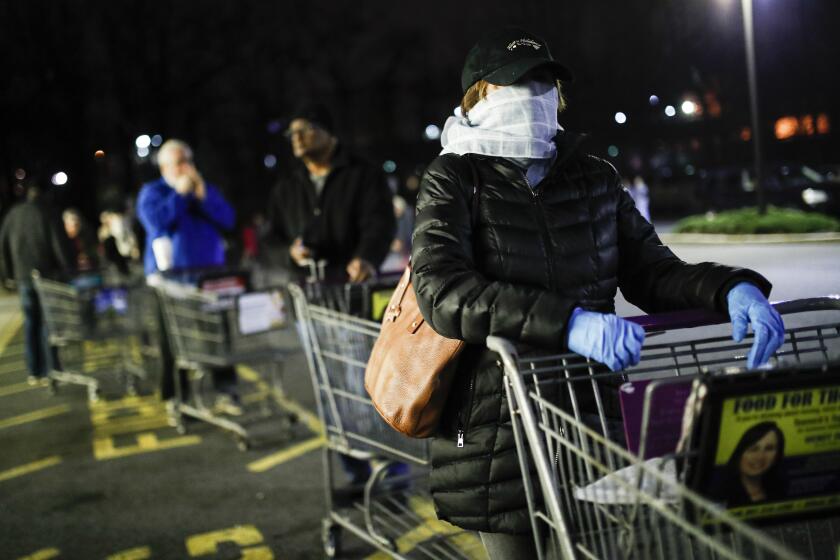 Customers wearing protective masks and gloves wait in line at a Stop & Shop supermarket that opened special morning hours to serve people 60-years and older due to coronavirus concerns, Friday, March 20, 2020, in Teaneck, N.J. For most people, COVID-19, the disease caused by the new coronavirus, causes only mild or moderate symptoms, such as fever and cough. For some, especially older adults and people with existing health problems, it can cause more severe illness, including pneumonia. (AP Photo/John Minchillo)