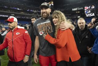 Chiefs tight end Travis Kelce and Taylor Swift embrace on the field after the AFC championship game.