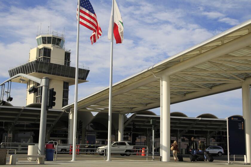 FILE - Travelers prepare to enter Oakland International airport Tuesday, Nov. 26, 2013, in Oakland, Calif. 