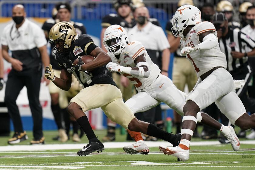 Colorado wide receiver Dimitri Stanley (14) runs past Texas defensive back D'Shawn Jamison (5) after a catch during the first half of the Alamo Bowl NCAA college football game Tuesday, Dec. 29, 2020, in San Antonio. (AP Photo/Eric Gay)