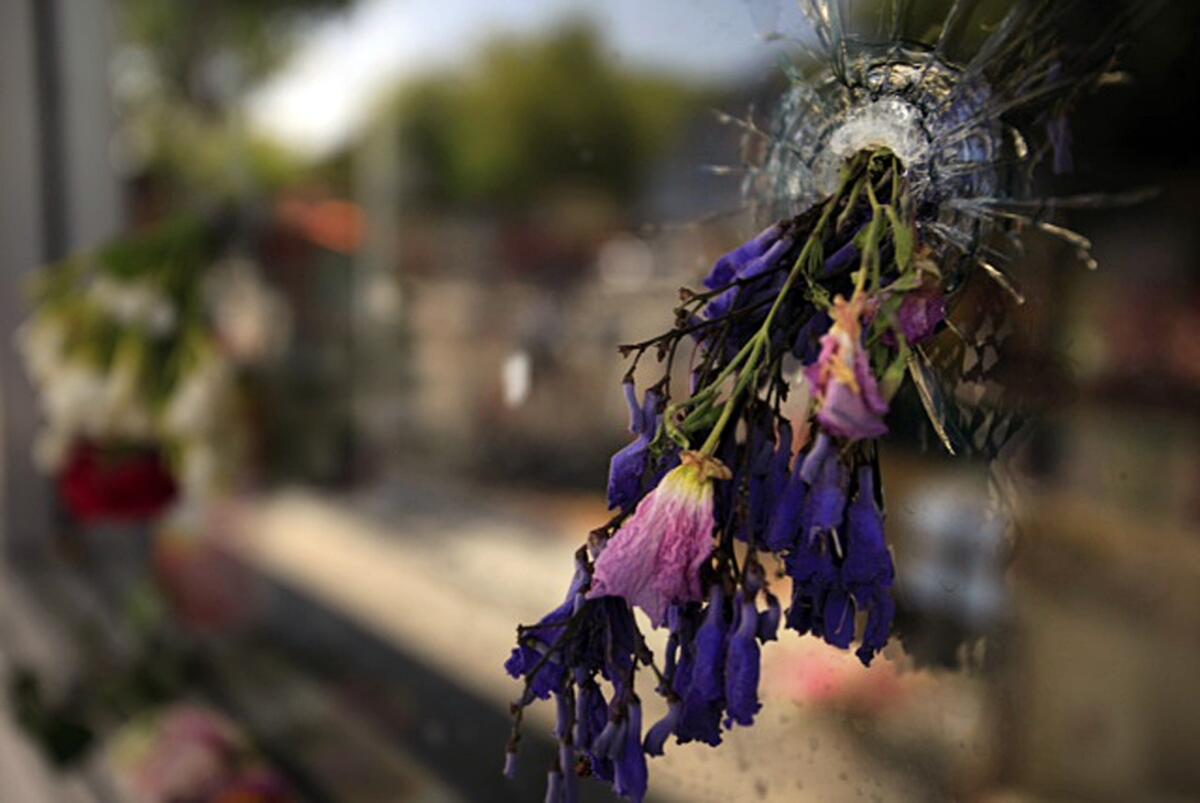 Flowers placed at the I.V. Deli in Isla Vista on May 25, 2014, form a part of a makeshift memorial to victims of a shooting rampage.