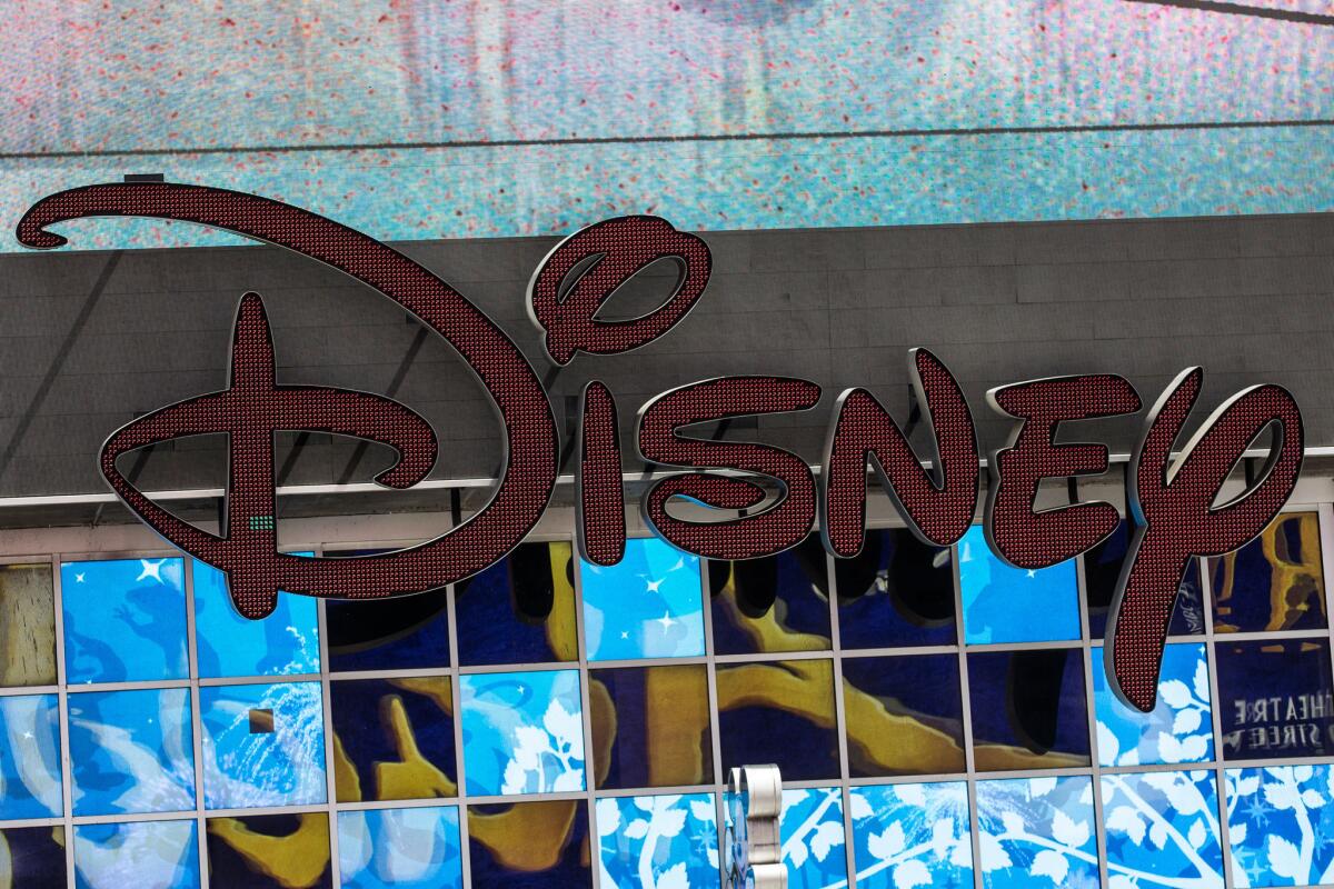 A sign hangs on the Disney store in Times Square in New York City. Stock prices of media companies fell Thursday.