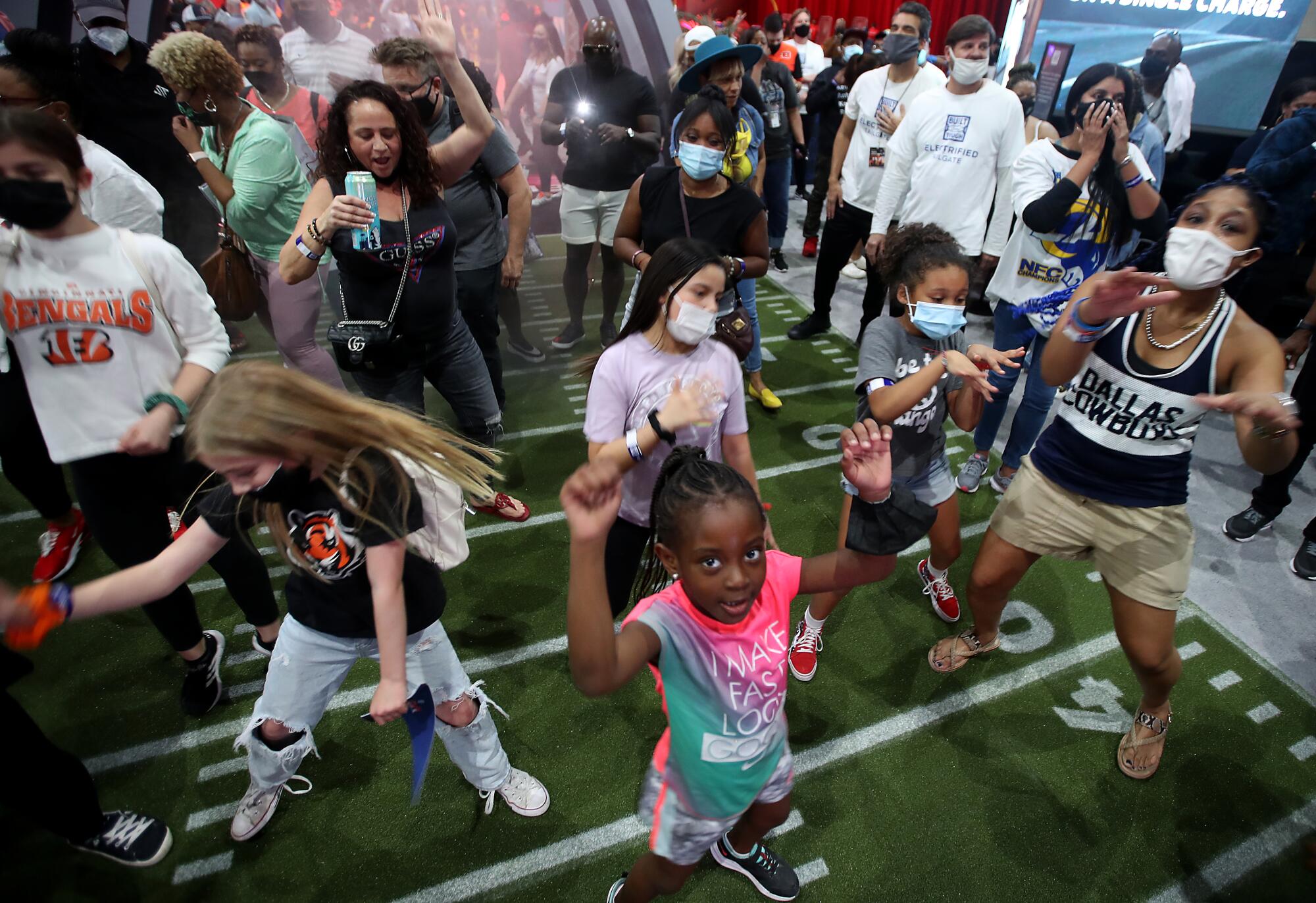 Young football fans dance to the beats of a deejay during the Super Bowl Experience.