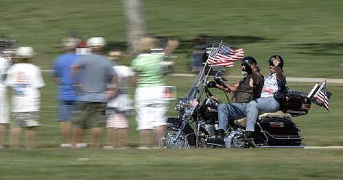 PATRIOTIC: Motorcyclists wave as they ride into Riverside National Cemetery to commemorate Memorial Day. Thousands of riders participated in the observance, one of many held in the Southland.