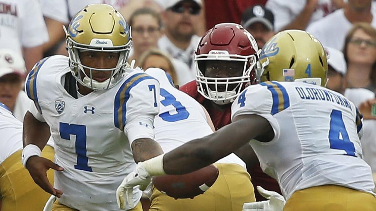 UCLA quarterback Dorian Thompson-Robinson hands off to running back Bolu Olorunfunmi against Oklahoma on Sept. 8.