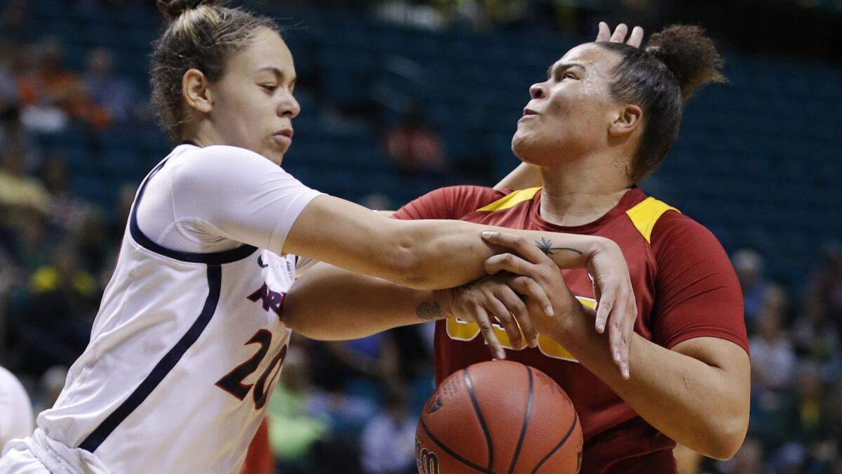 Arizona's Dominique McBryde, left, fouls USC's Kayla Overbeck during the first half at the Pac-12 women's tournament on Thursday in Las Vegas. (AP Photo/John Locher)