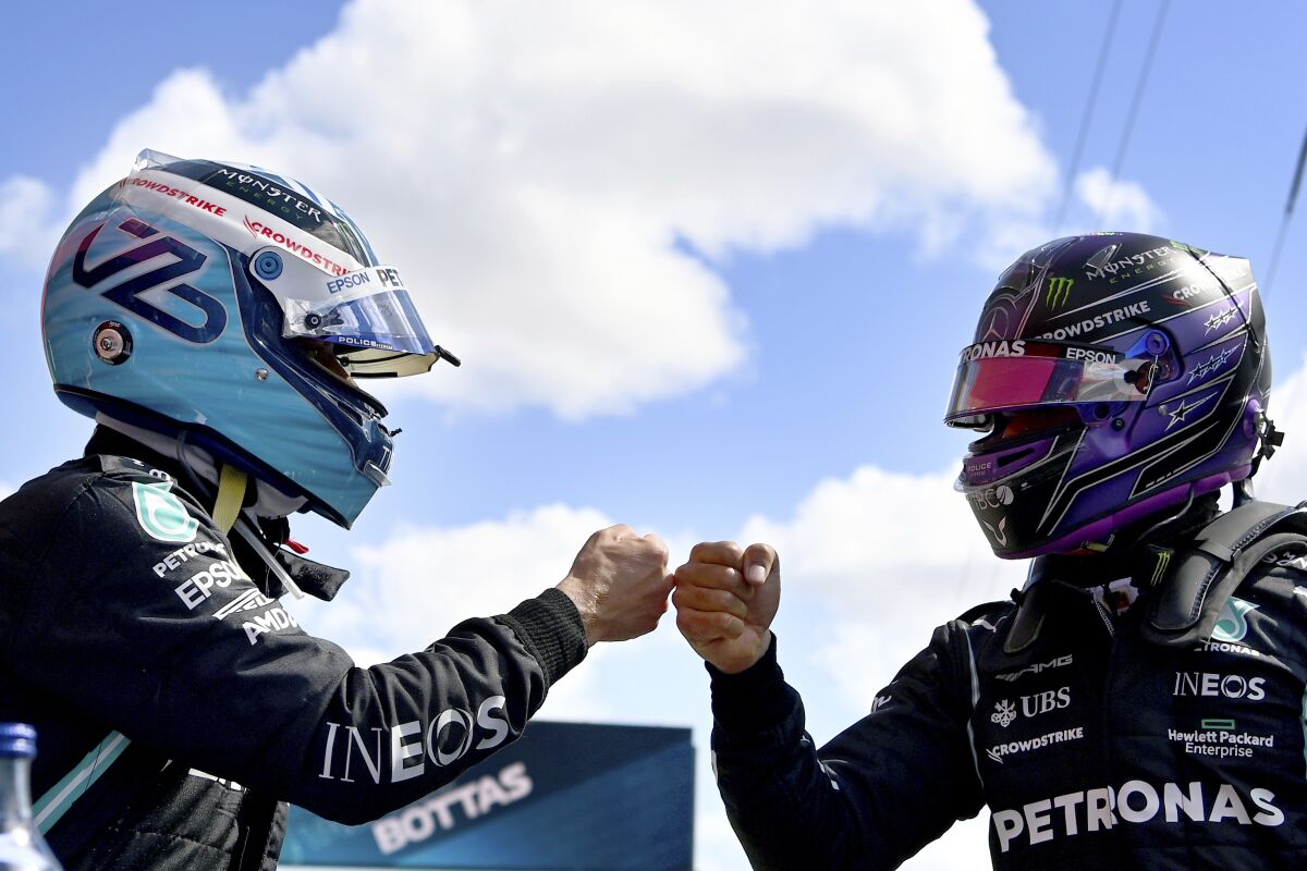 Mercedes driver Lewis Hamilton of Britain, right, congratulates Mercedes driver Valtteri Bottas of Finland after he clocked the fastest time during the qualifying session ahead of the Portugal Formula One Grand Prix at the Algarve International Circuit near Portimao, Portugal, Saturday, May 1, 2021. The Portugal Grand Prix will be held on Sunday. (Gabriel Buoys/Pool via AP)