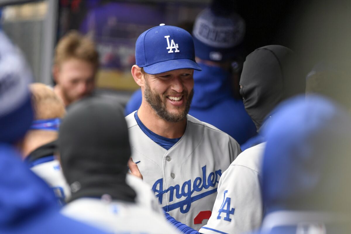 Los Angeles Dodgers pitcher Clayton Kershaw celebrates with teammates after a perfect game through seven innings in his season debut, dominating the Minnesota Twins with 13 strikeouts in 21 batters on Wednesday, April 13, 2022, in Minneapolis. (AP Photo/Craig Lassig)