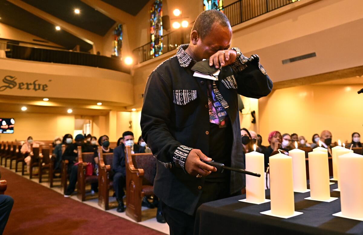 A man weeps as he lights a candle in a church