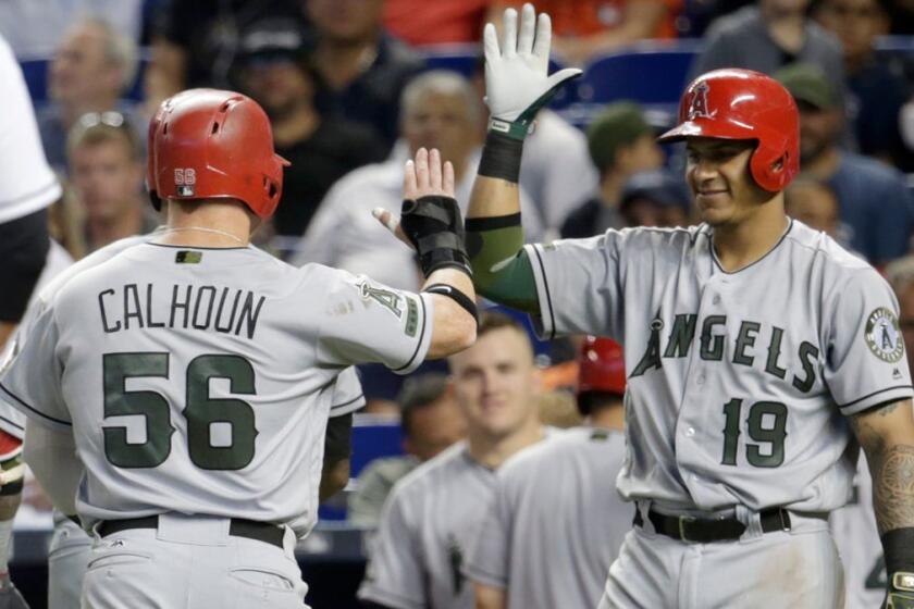 Los Angeles Angels' Kole Calhoun (56) is met by Jefry Marte (19) after scoring on a two-run home run hit by Martin Maldonado during the fifth inning of an interleague baseball game against the Miami Marlins, Sunday, May 28, 2017, in Miami. (AP Photo/Lynne Sladky)