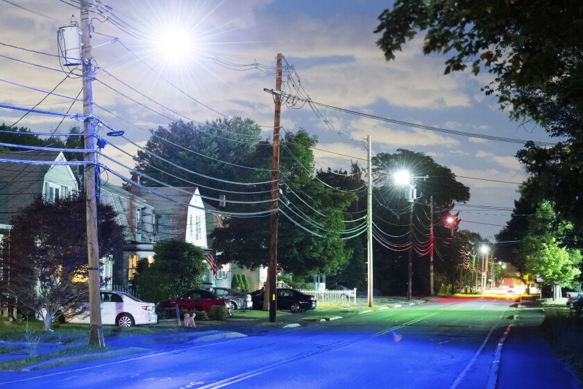 This image provided by Daniel F. Borelli shows a street in Ashland, Mass. Visual artist Dan Borelli worked with officials in his Ashland to filter street lights in colors that corresponded to the density of toxic waste beneath streets, homes, and businesses. (Justin Knight/Daniel F. Borelli via AP)