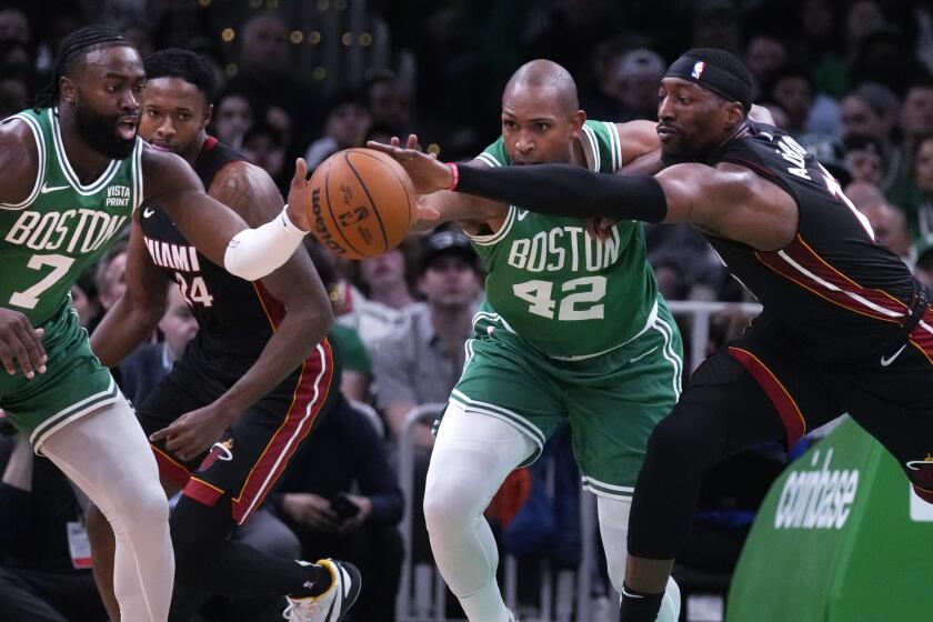 Miami Heat center Bam Adebayo, right, battles for the ball against Boston Celtics center Al Horford and guard Jaylen Brown during the first half of Game 2 of an NBA basketball first-round playoff series, Wednesday, April 24, 2024, in Boston. (AP Photo/Charles Krupa)