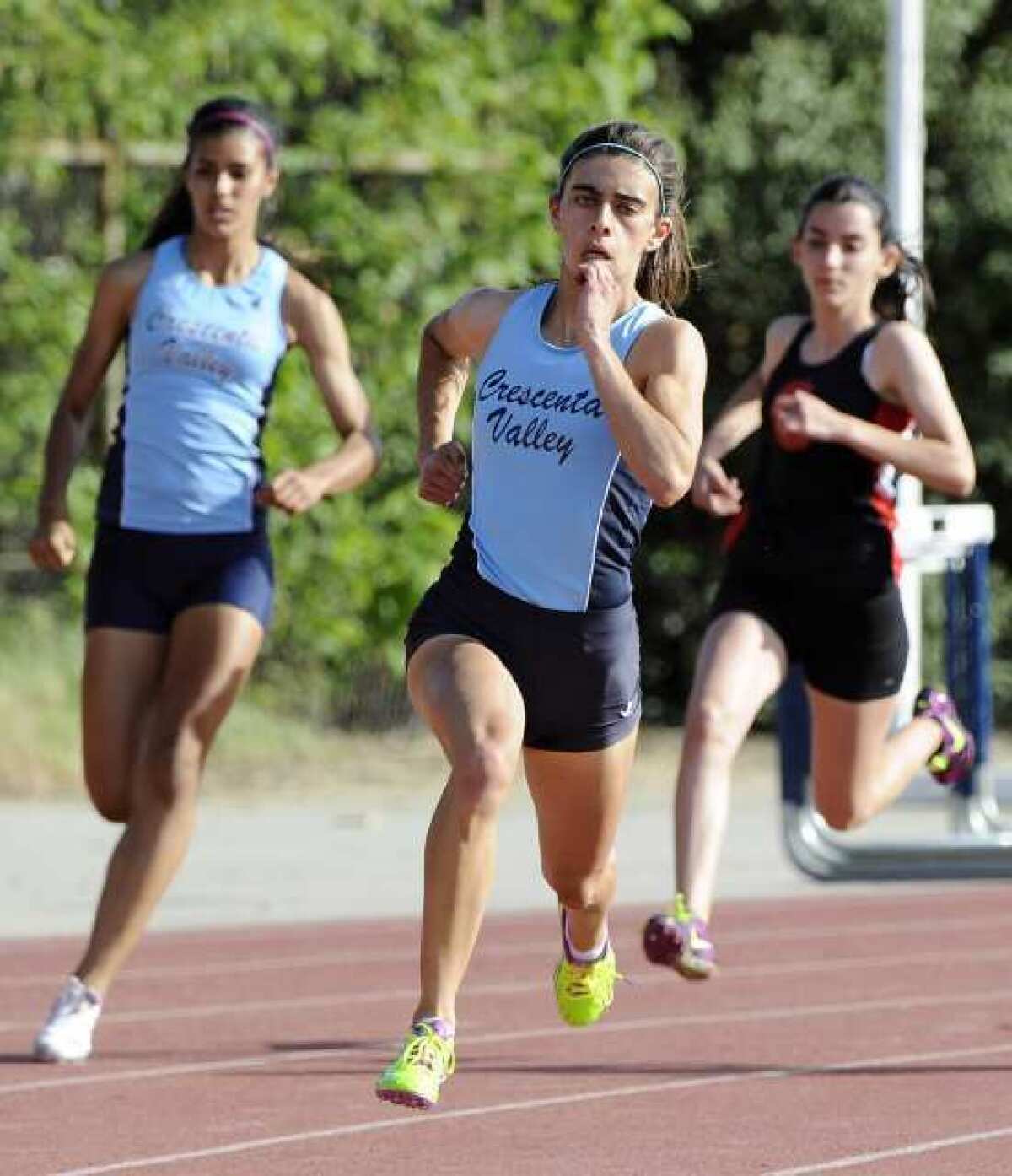 Crescenta Valley's Kayleigh Carrillo, center, leads before eventually winning the 200-meter race in a dual meet with Glendale High.