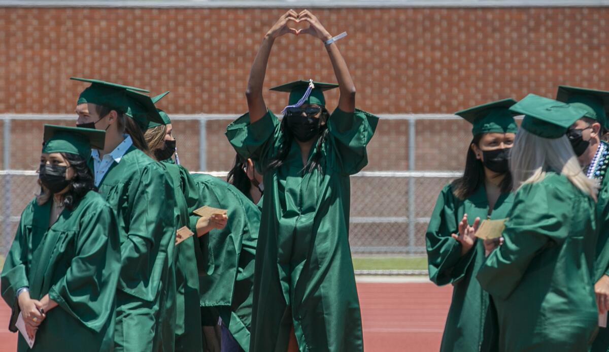 Tarah Harmon makes a heart sign with her hands during Costa Mesa High School's June 10 commencement ceremony.