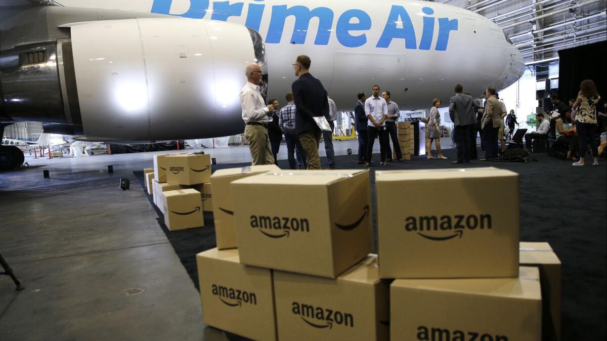 Amazon.com boxes are shown stacked near a Boeing 767 Amazon "Prime Air" cargo plane in Seattle. Economists say Amazon has displaced jobs in the retail sector.