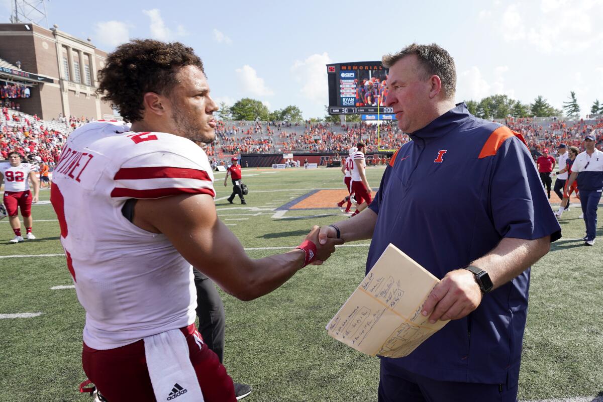 Nebraska quarterback Adrian Martinez, left, congratulates Illinois coach Bret Bielema after a game Aug. 28, 2021.