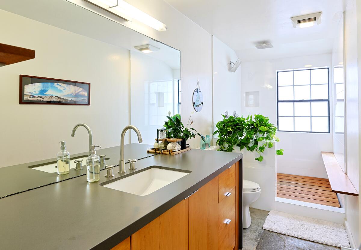 The Quonset hut’s light-filled master bathroom includes teak accents.