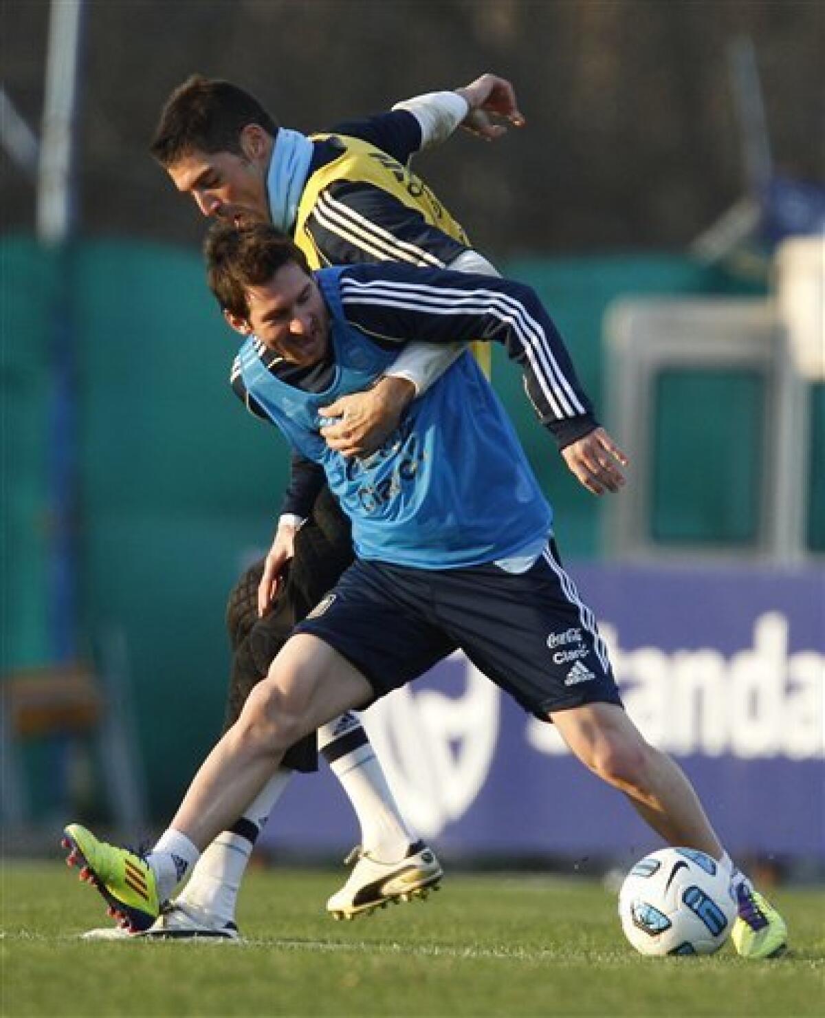 Argentina's Lionel Messi, left, fights for the ball with teammate Mariano Andujar during a training session ahead of the upcoming 2011 Copa America in Buenos Aires, Argentina, Wednesday, June 29, 2011. Argentina will host the Copa America soccer tournament July 1-24.(AP Photo/Natacha Pisarenko)