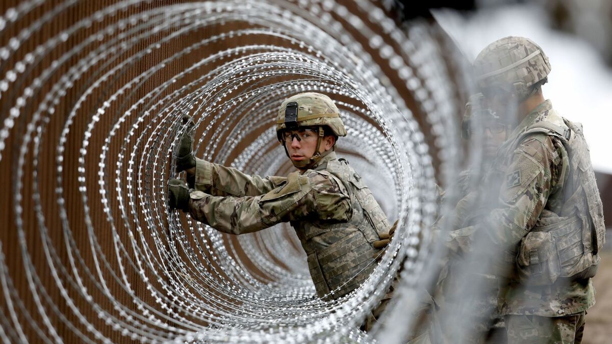 U.S. Army Spc. Alexander Gomez installs concertina wire near the banks of the Rio Grande on the border in Brownsville, Texas.