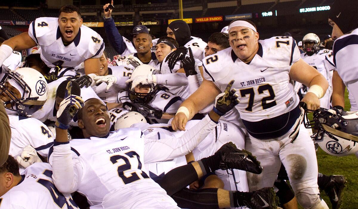 St. John Bosco football players celebrate after defeating Mater Dei, 34-7, in the Southern Section Pac-5 Division championship game at Angel Stadium last fall.