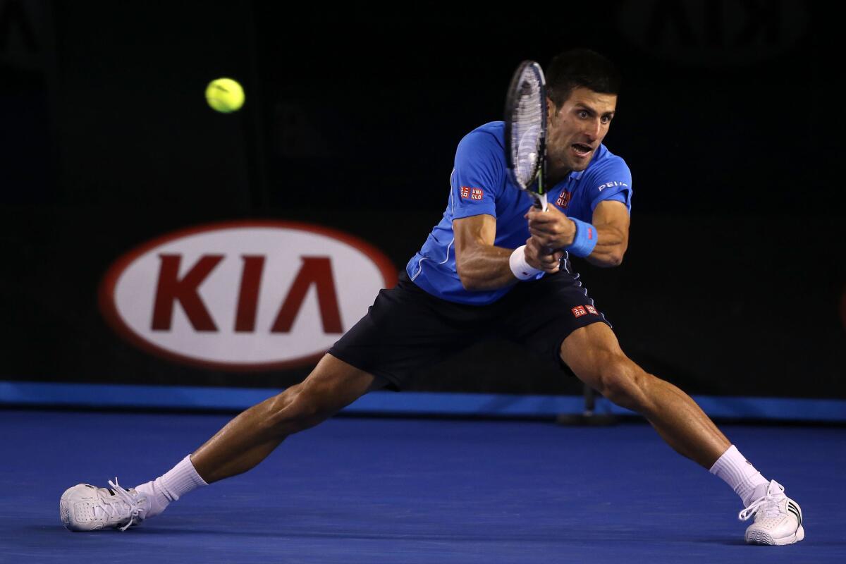 Novak Djokovic chases down a backhand return during his five-set victory over defending champion Stan Wawrinka in an Australian Open semifinal on Saturday in Melbourne.