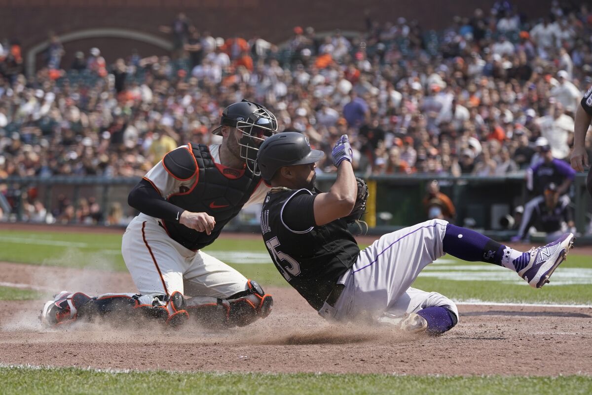 San Francisco Giants catcher Curt Casali, left, tags out Colorado Rockies' Elias Diaz at home during the seventh inning of a baseball game in San Francisco, Sunday, Aug. 15, 2021. (AP Photo/Jeff Chiu)
