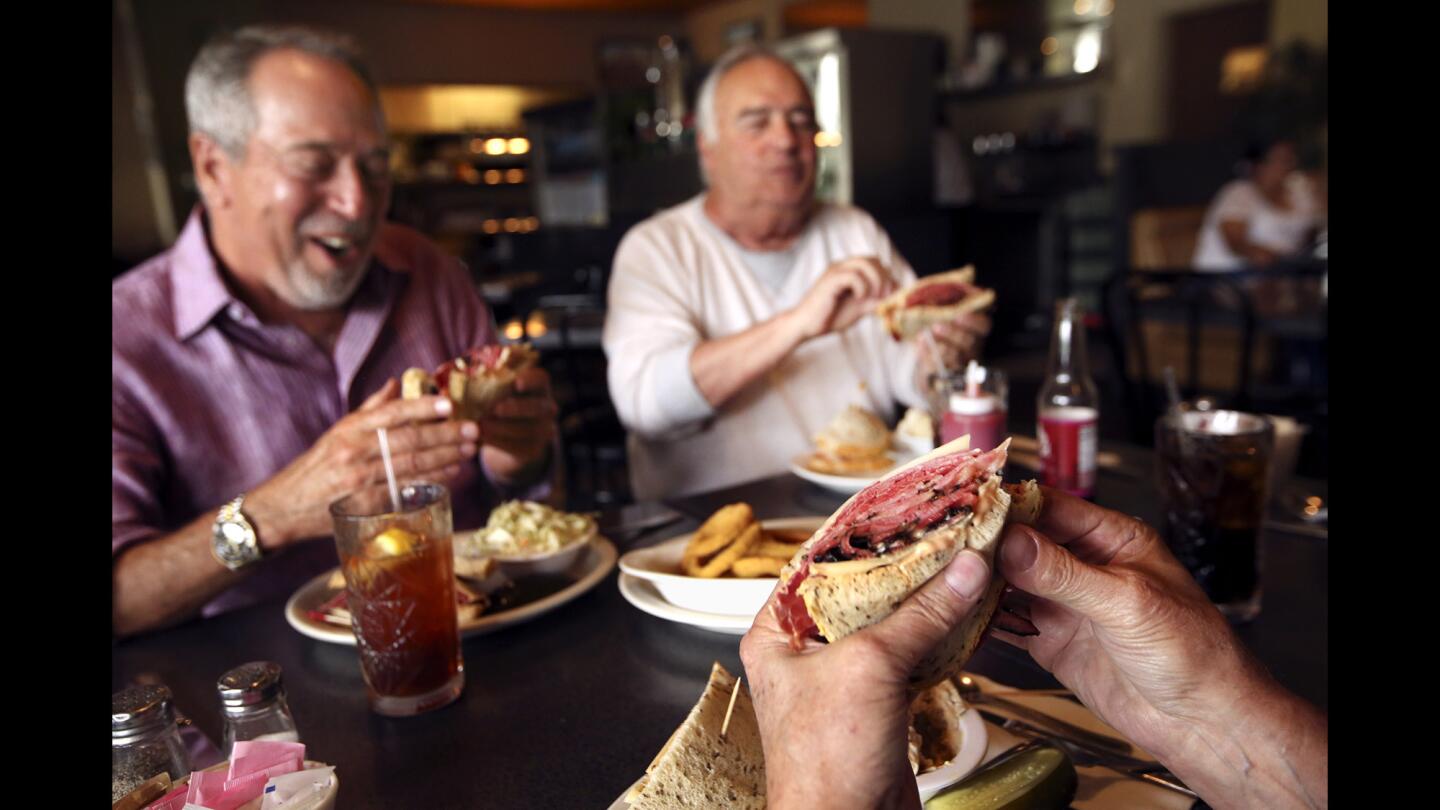 Customers Harvey Rosen, left, Larry Berkowitz, right, and Peter Kares, foreground, enjoy the No. 35 sandwich -- pastrami, corned beef and Swiss cheese on rye, with Russian dressing -- at Victor's Square Restaurant in Hollywood. After 32 years, owner Bill Gotti recently closed the popular deli.
