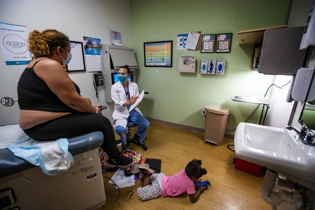 A doctor speaks to a patient in an examination room 