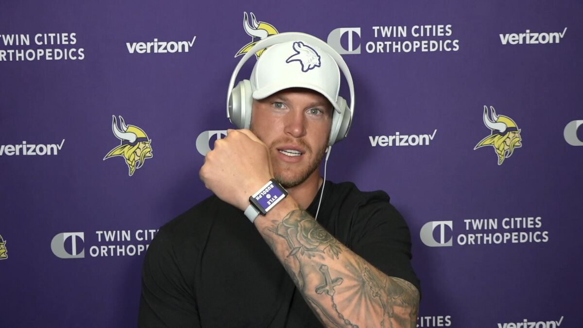 This photo taken Aug. 5, 2020, during a Zoom interview with reporters, Vikings tight end Kyle Rudolph, displays the proximity tracking device that players and staff around the NFL are wearing at team facilities as part of COVID-19 protocols.