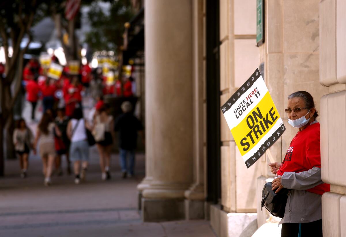 A striking member of Unite Here Local 11 pickets outside the Biltmore Hotel in downtown Los Angeles on Sunday.