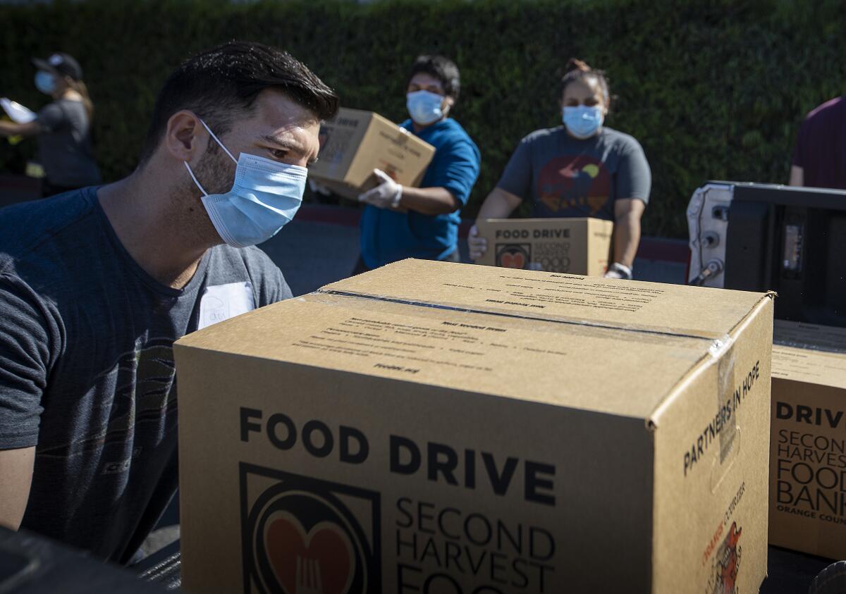 People load boxes of food into trucks to be delivered to Orange County senior centers