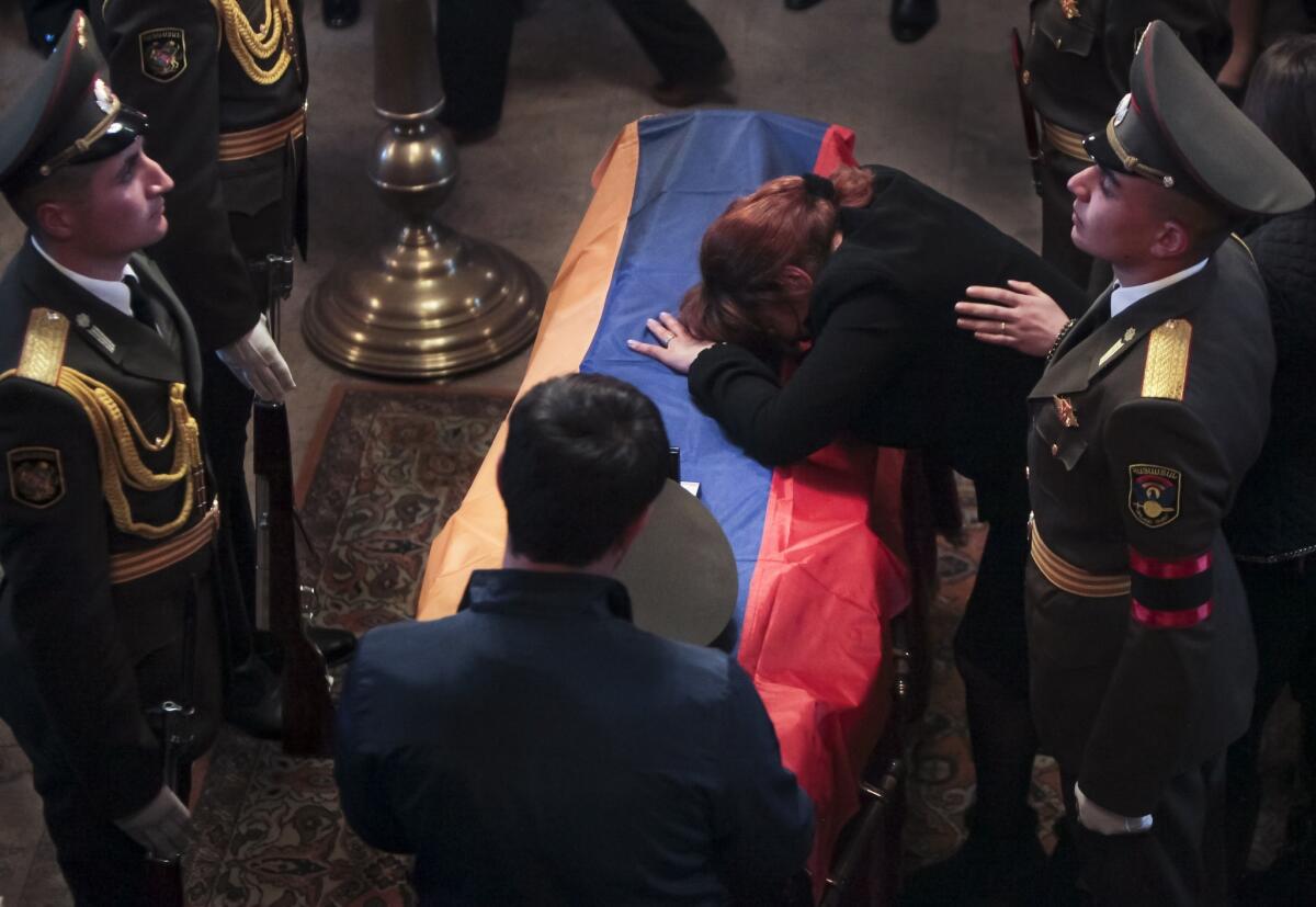 The mother of Karabakh military officer Armenak Urfanyan grieves at a coffin with the body of her son who was killed in fighting around Nagorno-Karabakh, during a funeral ceremony in a church in Yerevan, Armenia, Tuesday, April 5, 2016. Azerbaijani and Armenian forces had been engaged in fighting around Karabakh since Saturday.