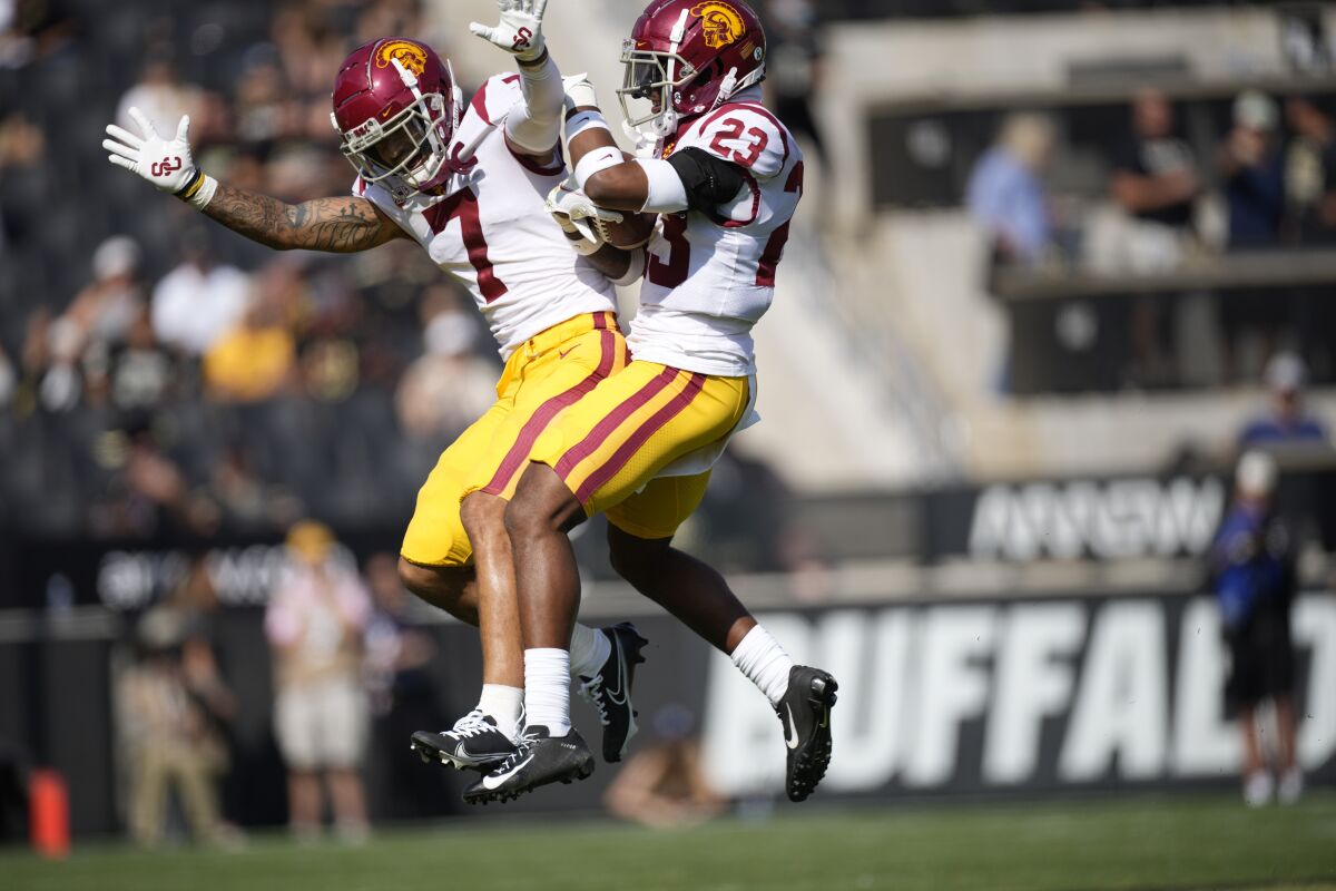 USC safety Chase Williams celebrates with cornerback Joshua Jackson Jr. after pulling in an interception 